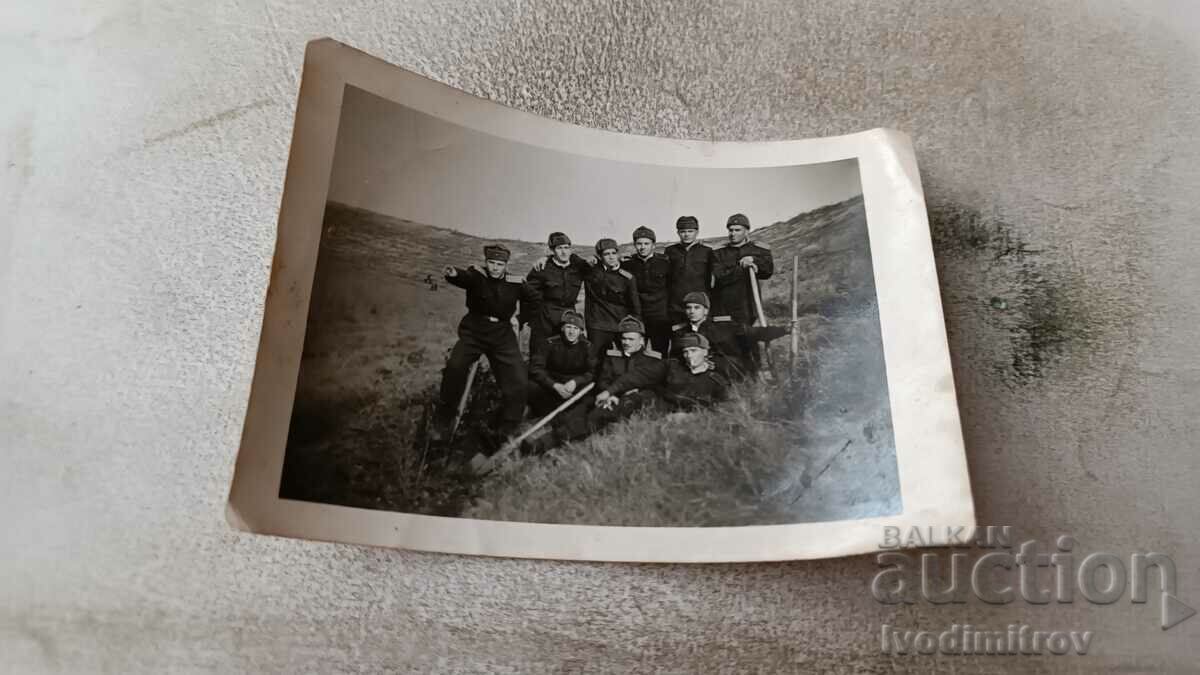 Φωτογραφία Στρατιώτες με λαβές και φτυάρια σε ένα λιβάδι
