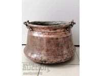 An old copper cauldron crushes a copper copper vessel