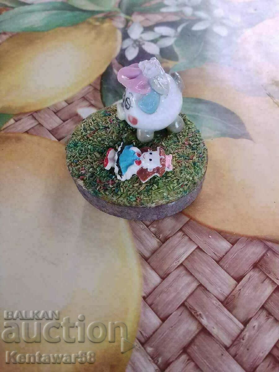 Porcelain figures on a wooden stand.