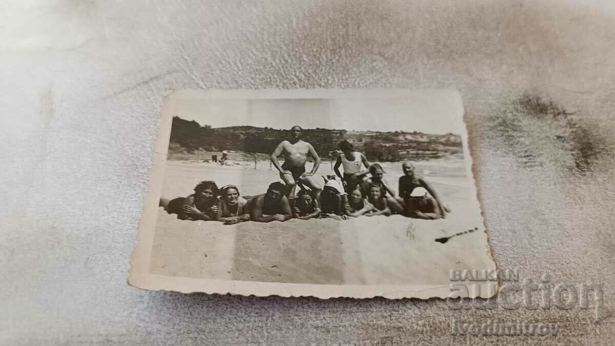 Photo Young men and women lying on the beach