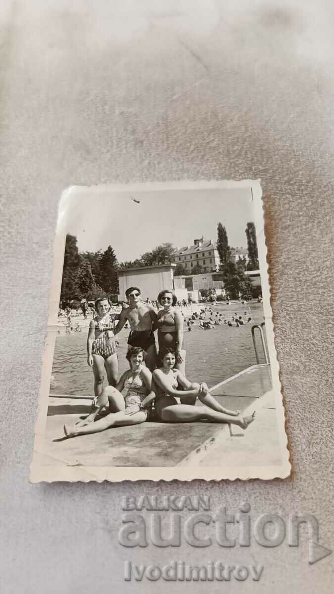 Снимка Млад мъж и млади жени на плувен басейн