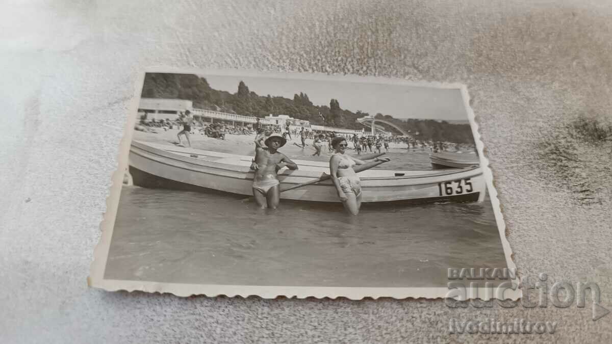 Φωτογραφία Νεαρός άνδρας και γυναίκα μπροστά σε μια βάρκα για εκδρομές