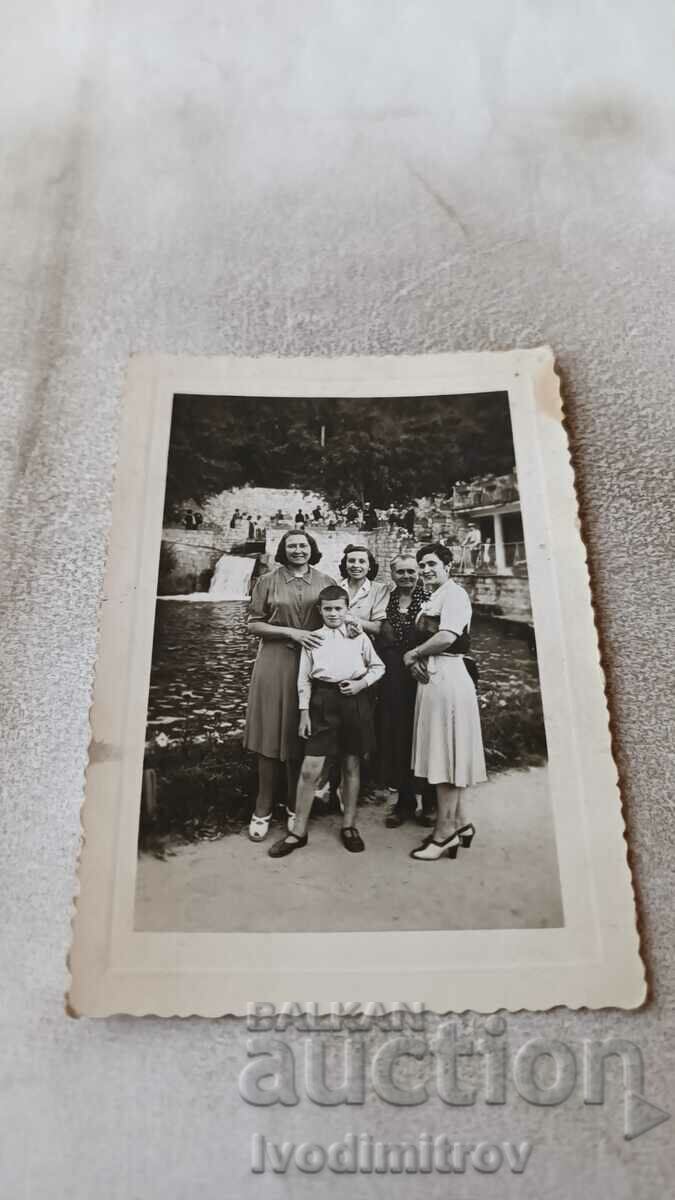 Photo Four women and a boy in front of a river dam 1943