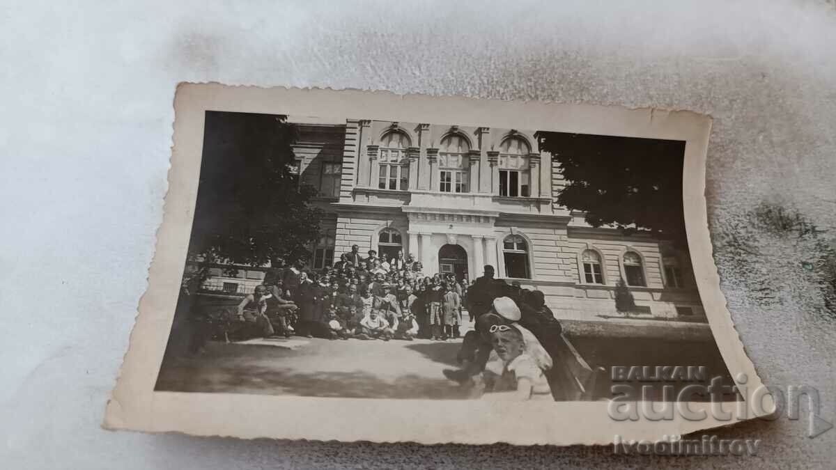 Foto Bărbați, femei și copii în fața unei clădiri administrative