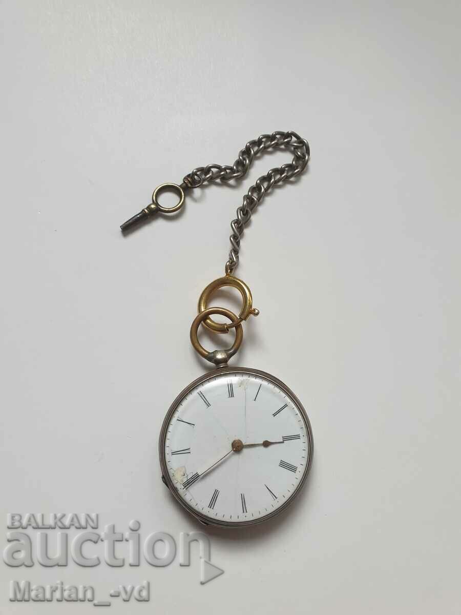 Old silver pocket watch with key