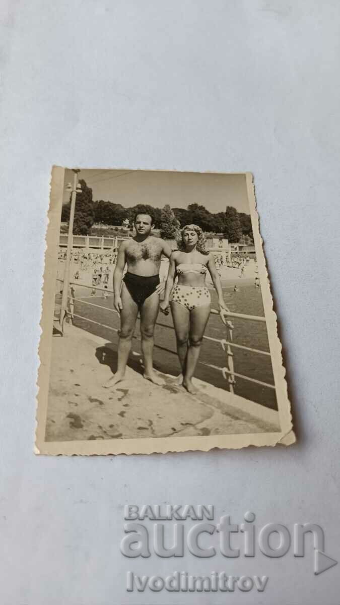 Photo Man and woman in swimsuits on the pier