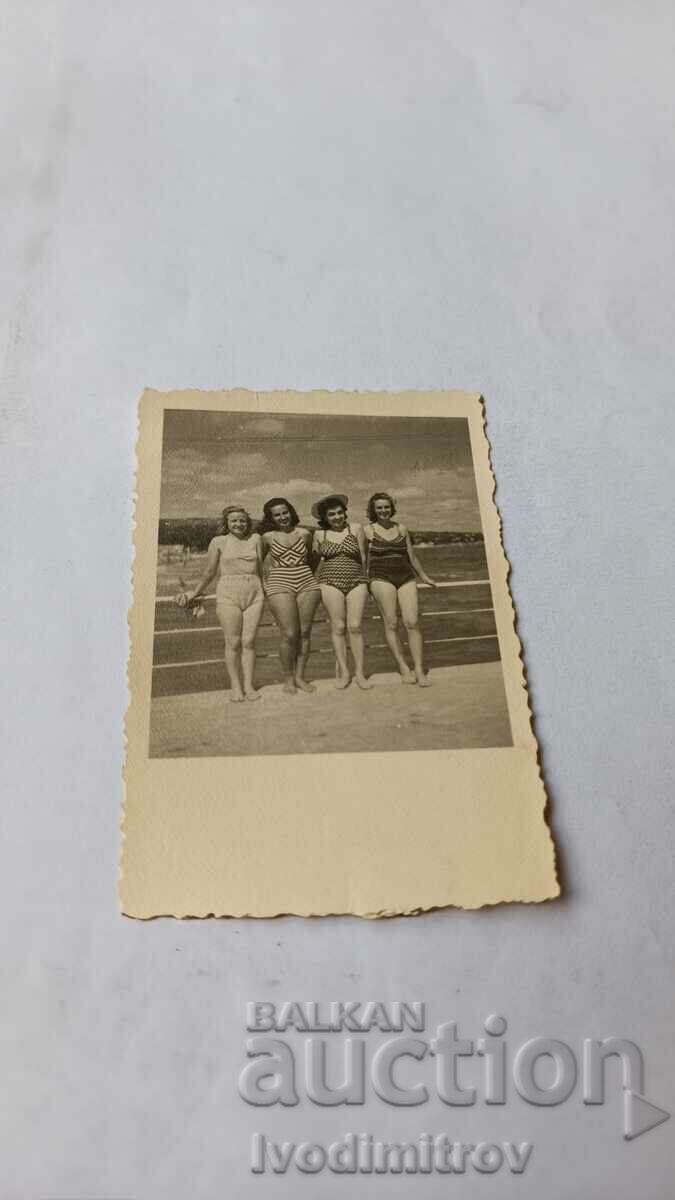 Photo Four women in swimsuits on the bridge