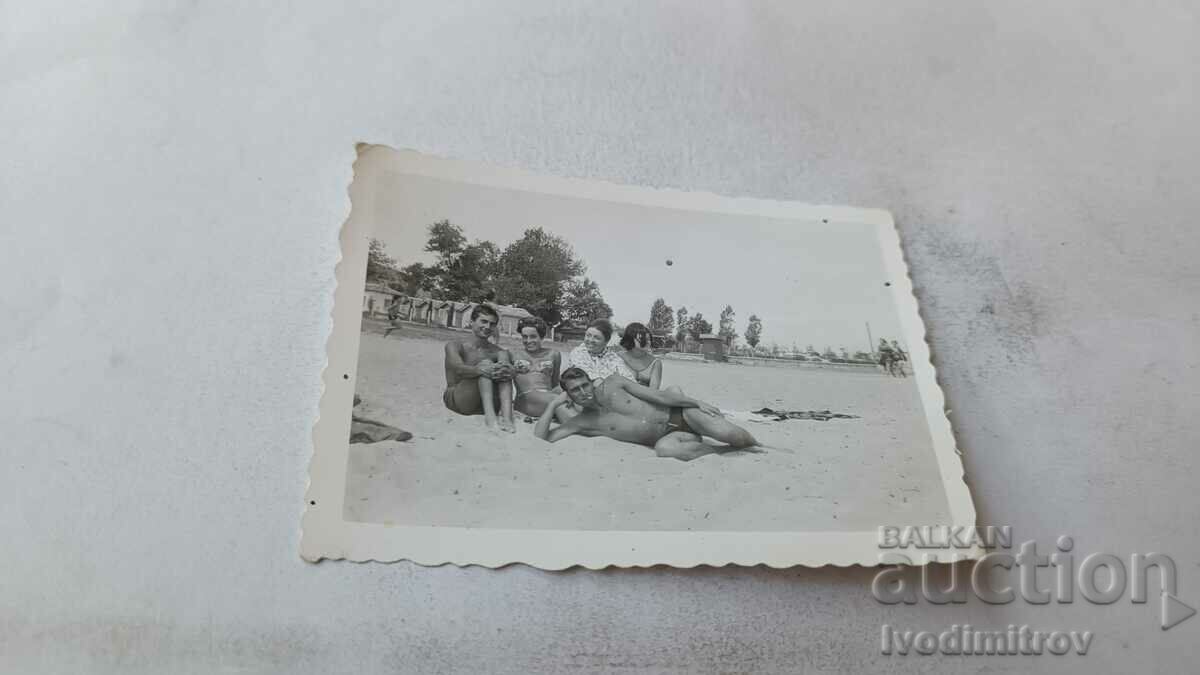 Foto Doi tineri și femei pe plajă