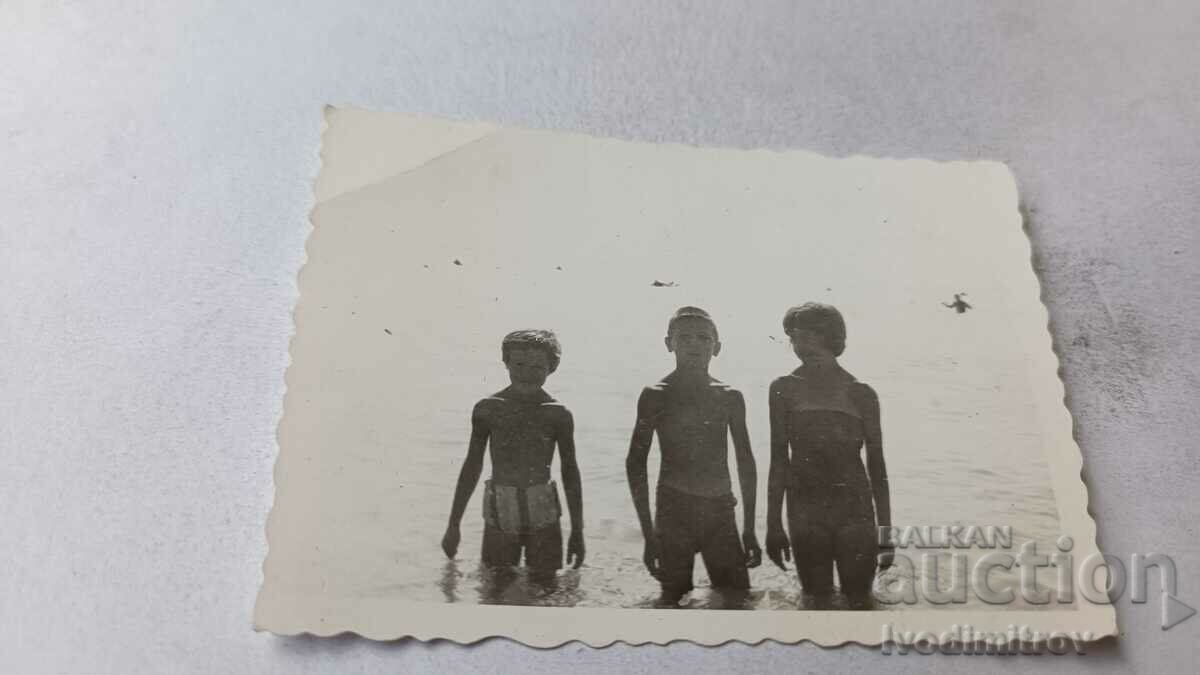 Foto Trei copii pe plajă