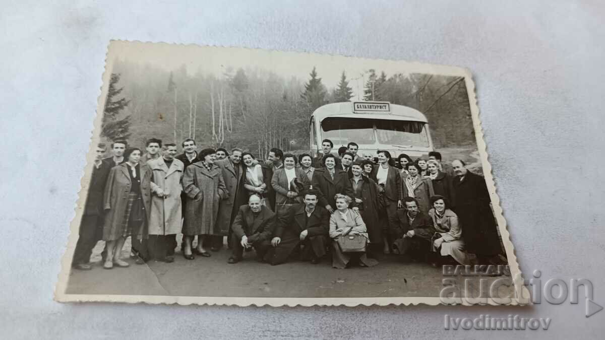 Φωτογραφία Άνδρες και γυναίκες μπροστά από βαλκαντουριστικό λεωφορείο στα βουνά