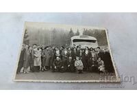 Fotografie Bărbați și femei în fața unui autobuz Balkantourist în munți