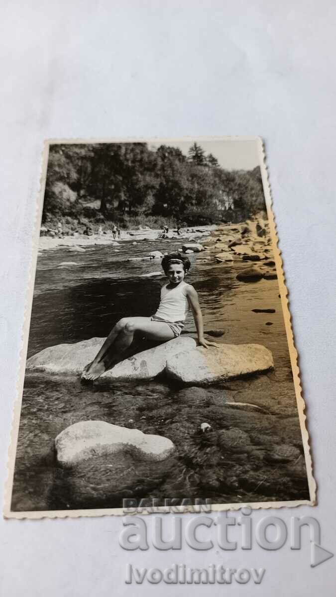Photo Young girl on a stone in the river