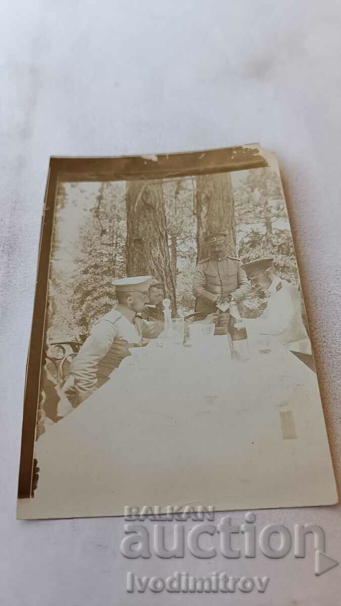Fotografie Patru ofițeri la o masă în pădure