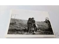 Φωτογραφία Ένας νεαρός άνδρας και ένα κορίτσι με μαγιό σε έναν ξύλινο πάγκο