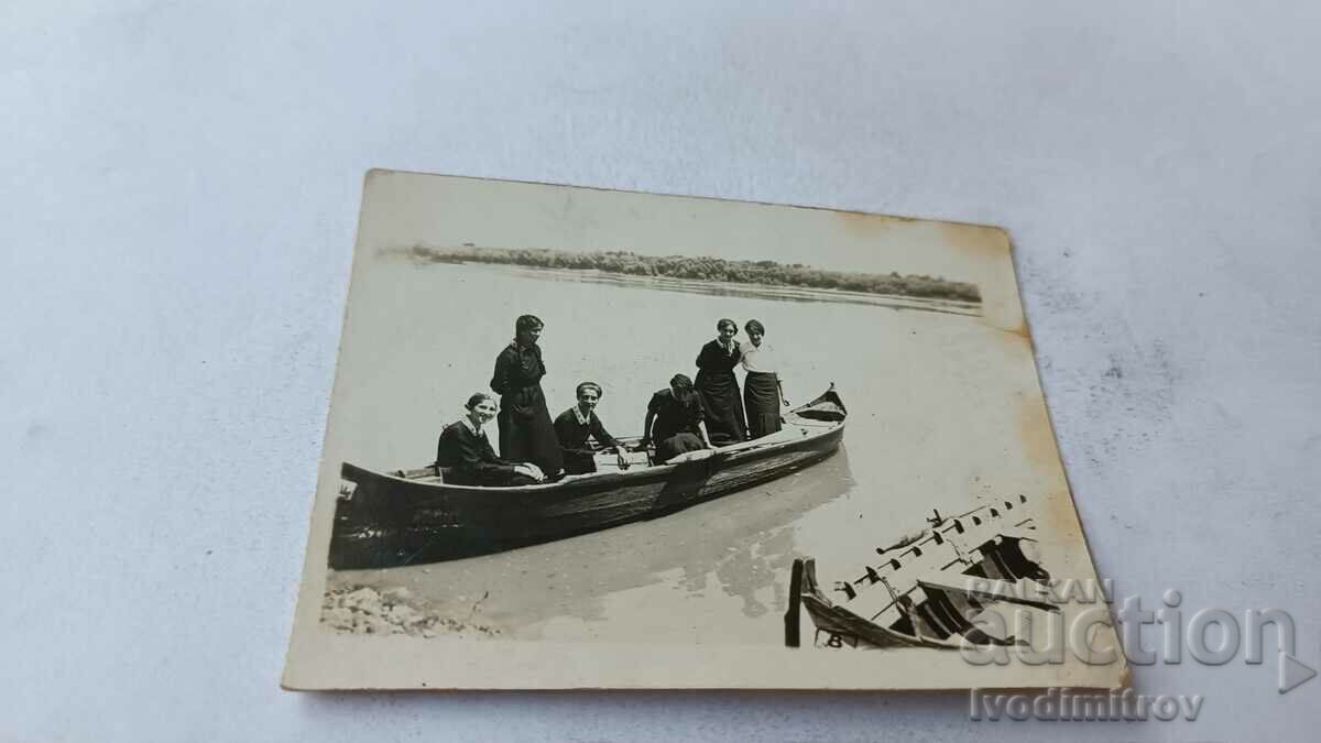 Photo Young girls with a wooden boat in the Danube river