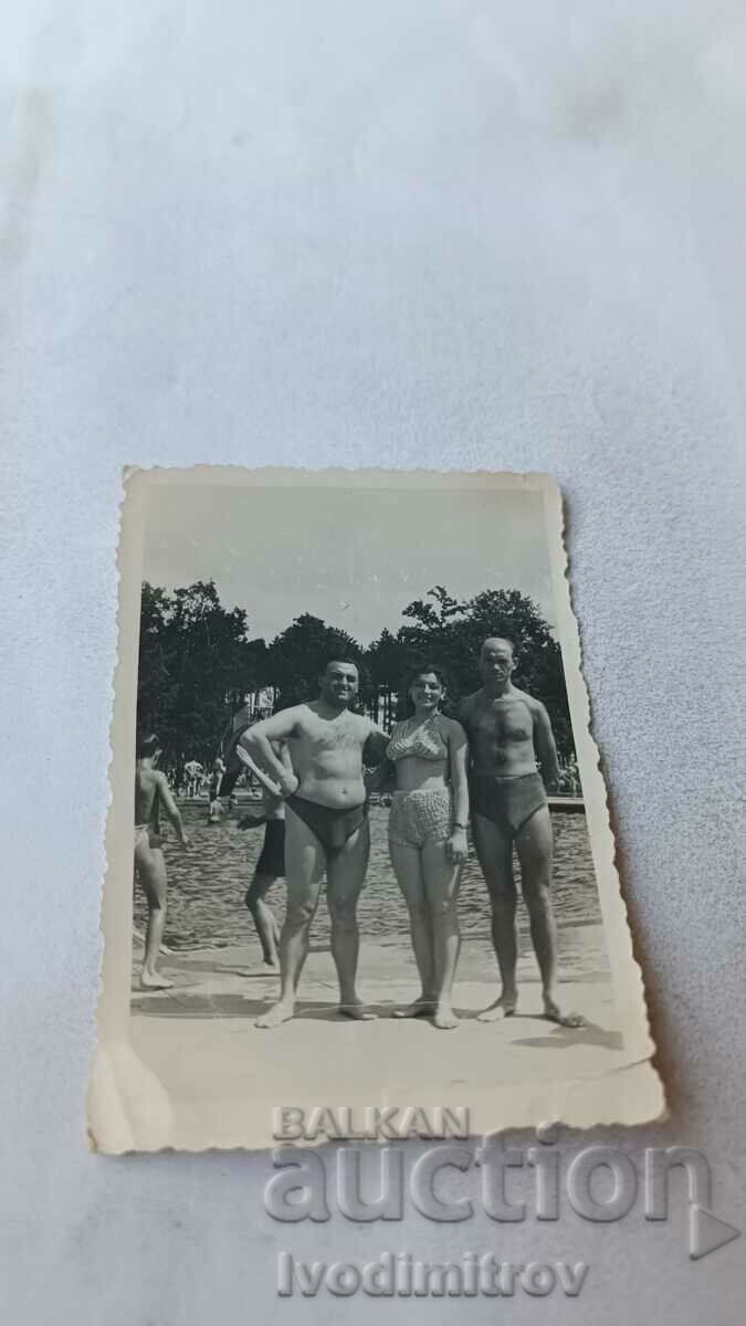 Photo Two men and a woman at a swimming pool