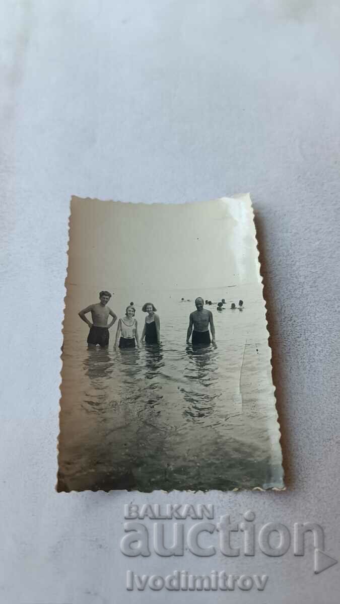 Снимка Двама мъже и две млади момичета на брега на морето