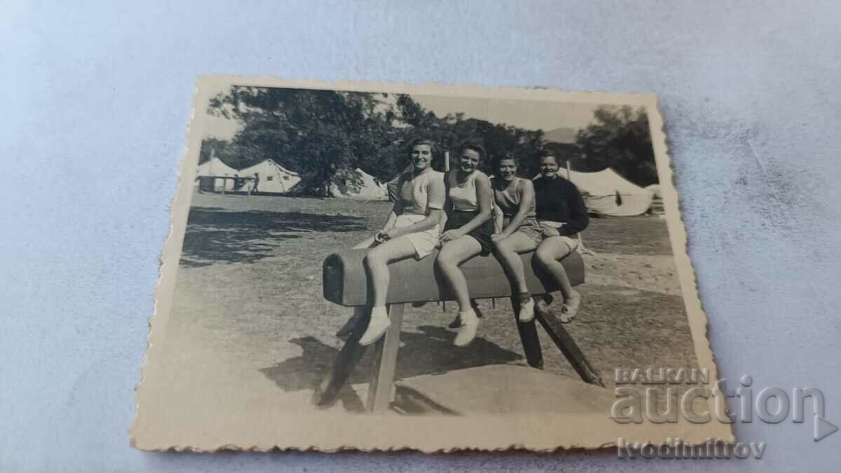 Φωτογραφία Τέσσερα νεαρά κορίτσια που κάθονται σε ένα γυμναστικό άλογο