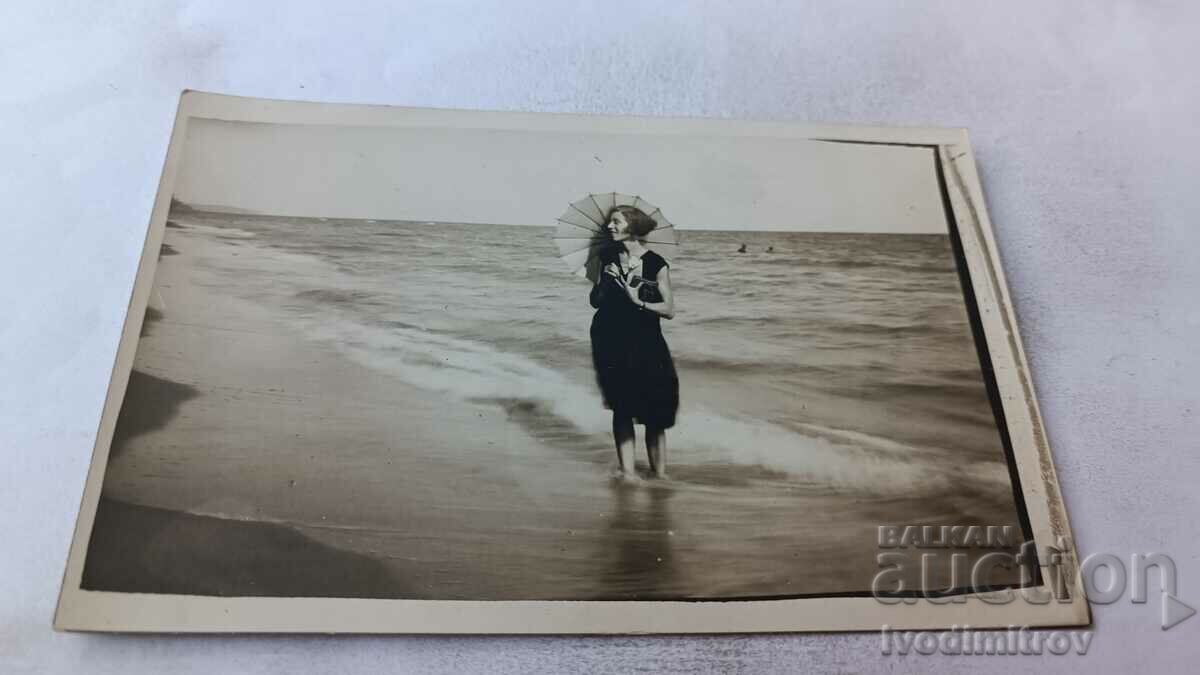 Foto Fată tânără cu o umbrelă pe plajă