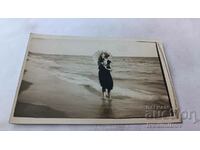 Снимка Младо момиче с чадърче на брега на морето