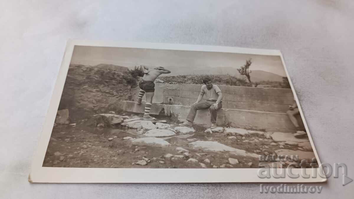 Photo Two men at a fountain in front of the town of Kalofer