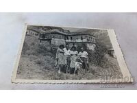 Снимка Мъже жени и момиченце пред стари родопски къщи