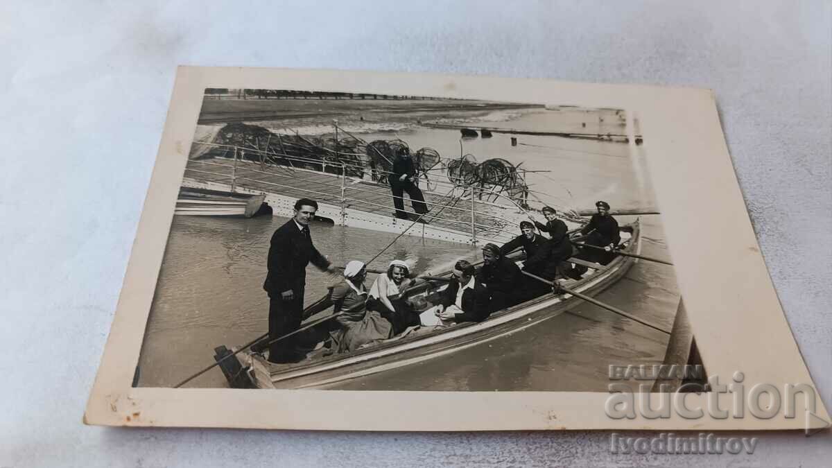 Photo Young men and women with a boat in the river
