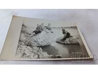 Fotografie Bărbați și femei pe stânci în râu