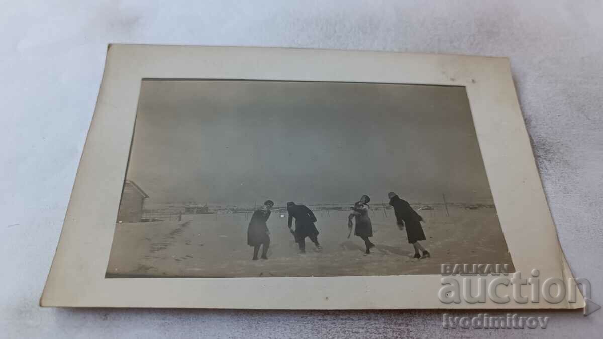 Φωτογραφία Ένας άνδρας και τρεις νεαρές γυναίκες παίζουν στο χιόνι