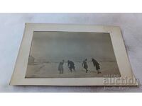 Photo A man and three young women are playing in the snow