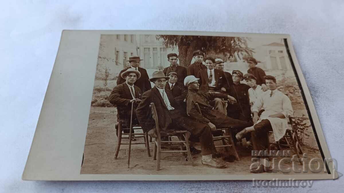 Fotografie Bărbați tineri stând pe scaune de lemn