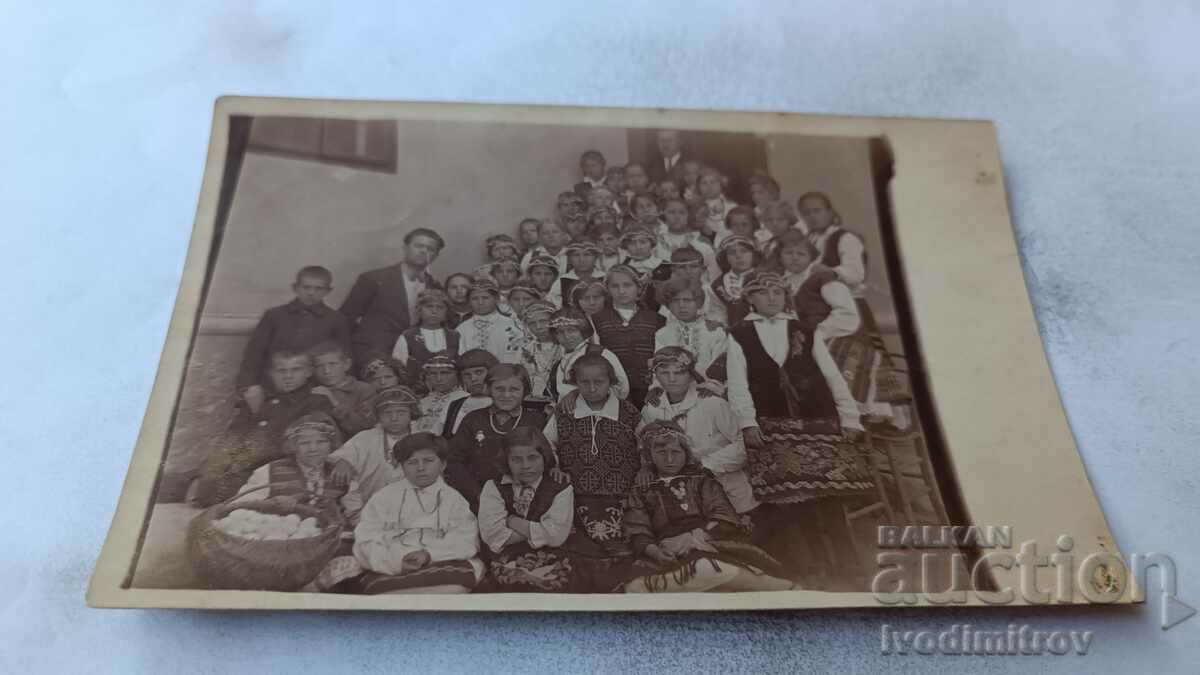 Photo Children in folk costumes with their teachers