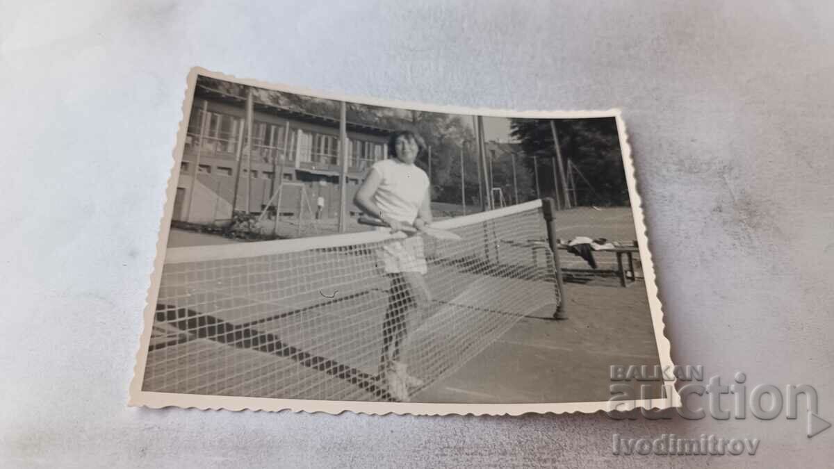 Φωτογραφία Νεαρή γυναίκα σε ένα γήπεδο τένις