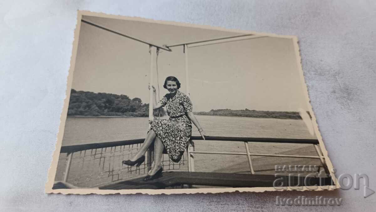 Φωτογραφία Νέα γυναίκα που κάθεται σε ένα κιγκλίδωμα