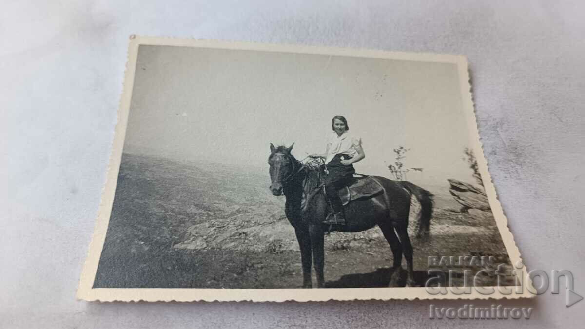 Φωτογραφία Νέα γυναίκα σε ένα μαύρο άλογο