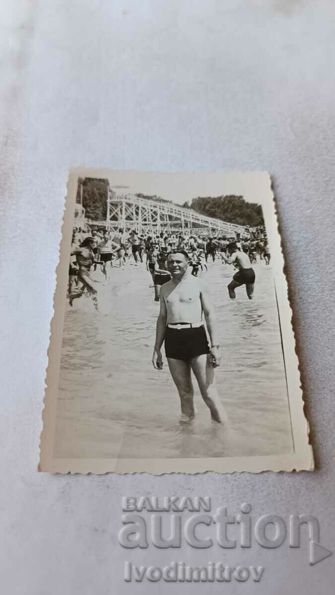 Fotografie Bărbat în costum de baie lângă mare