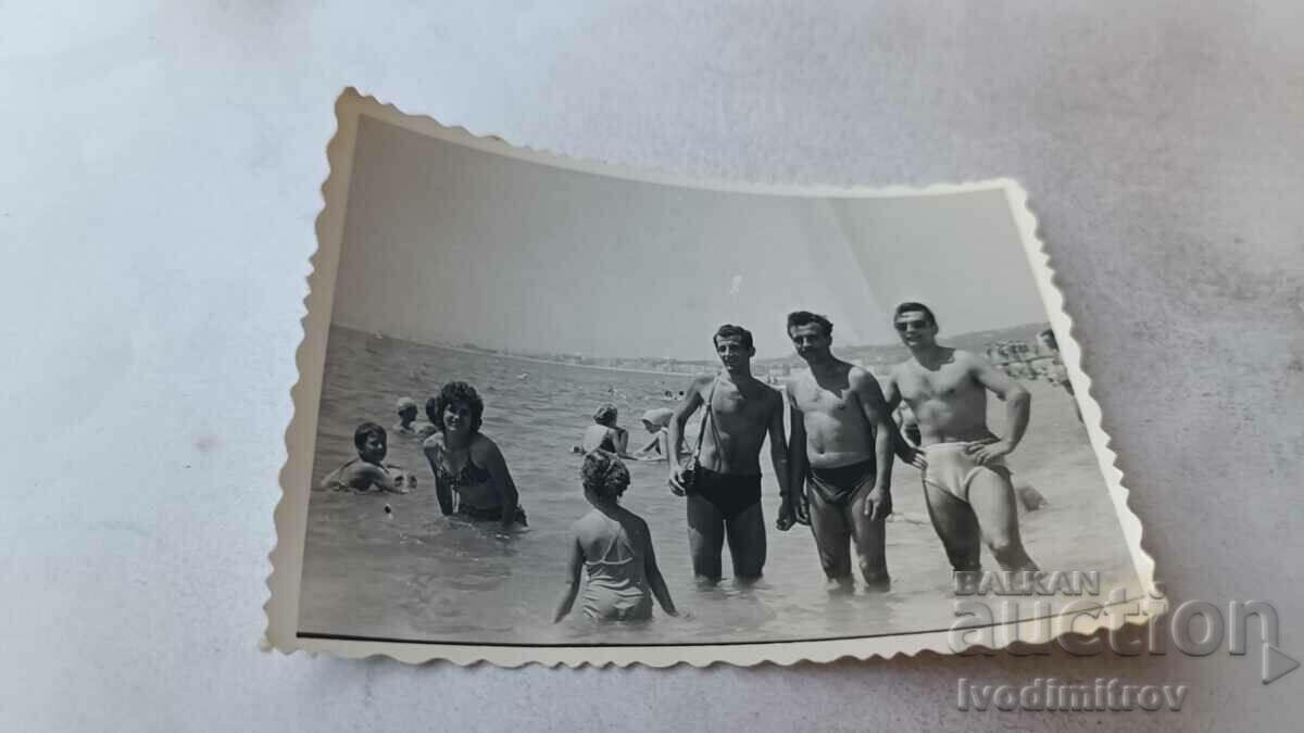 Φωτογραφία Τρεις άνδρες, μια γυναίκα και παιδιά στην παραλία