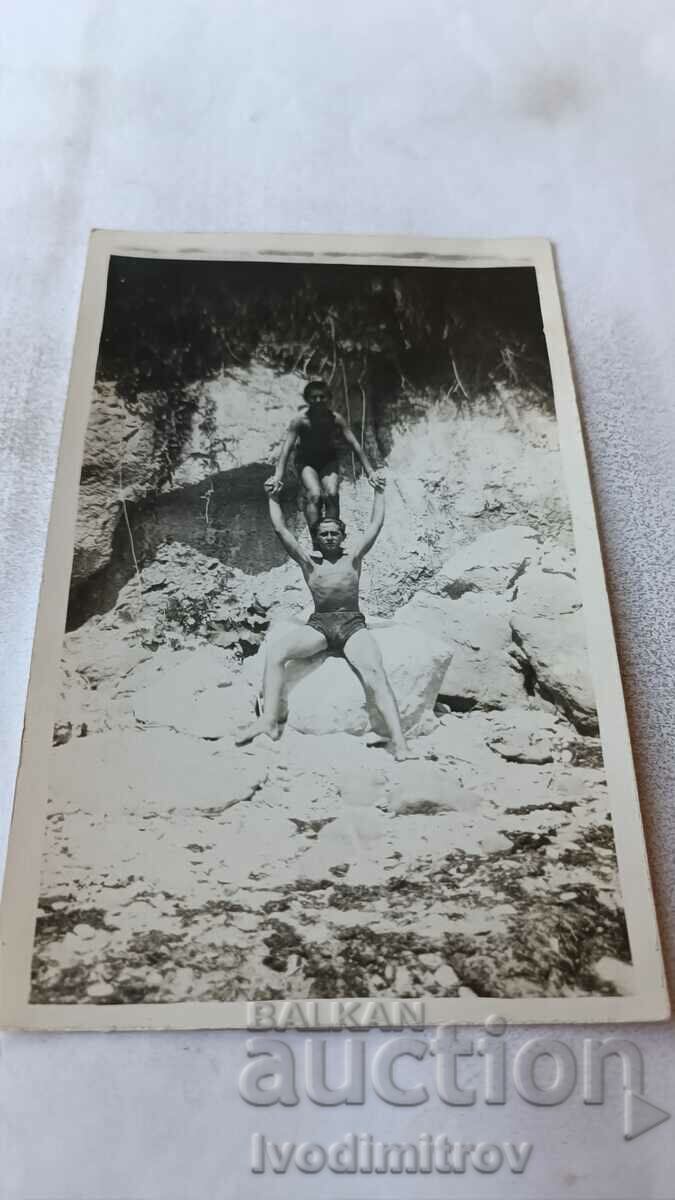 Photo Young man with a boy on his shoulders in a swimsuit