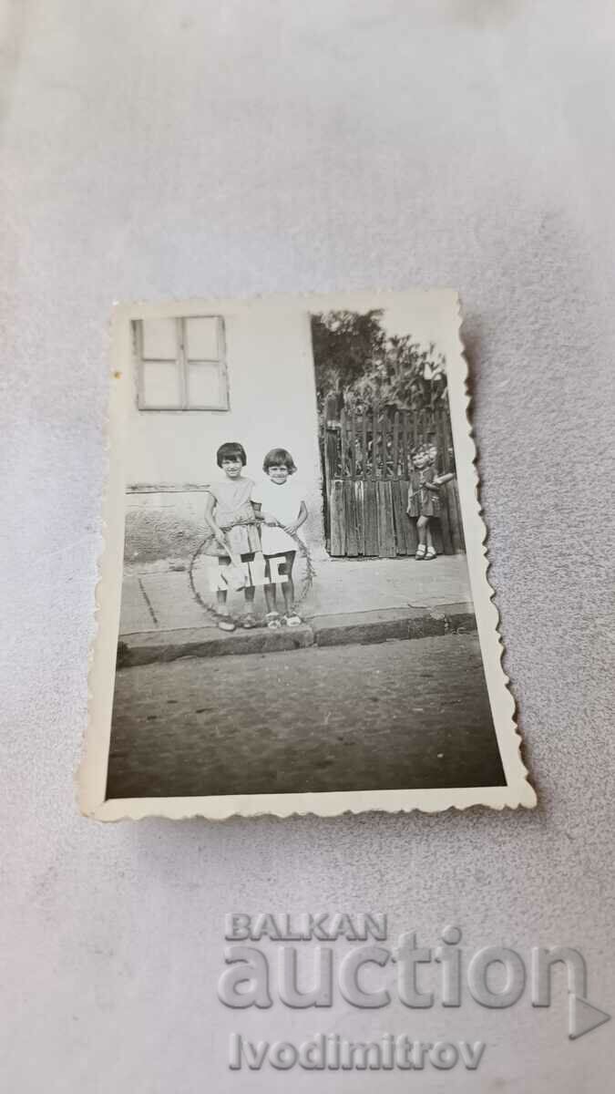 Foto Două fete cu un cerc pe trotuar