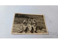 Снимка Млад мъж и две млади жени на скали край морето