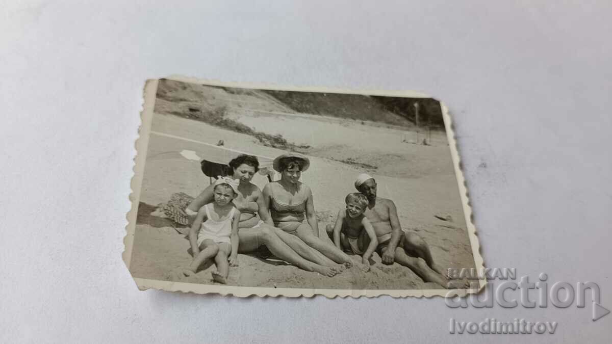 Photo Man two women and two children on the beach