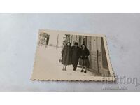 Φωτογραφία Σοφία Ένας άντρας και δύο γυναίκες με χειμωνιάτικα παλτό στο πεζοδρόμιο