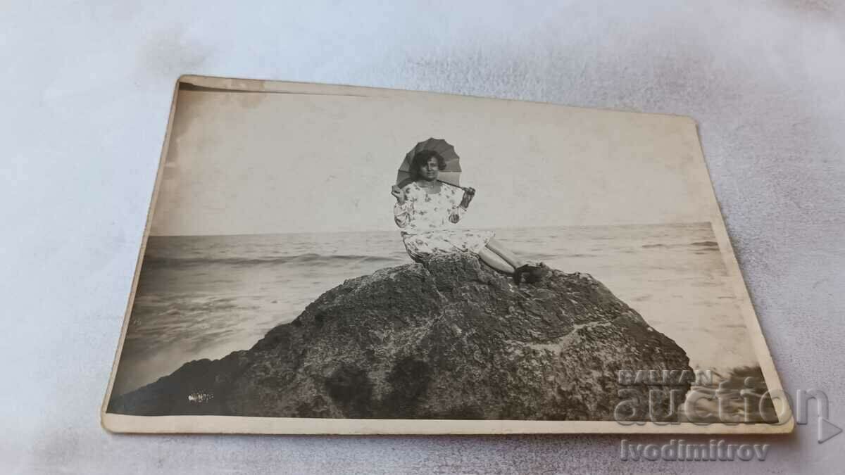 Снимка Жена в бяла рокля с чадър на скала край морето 1928
