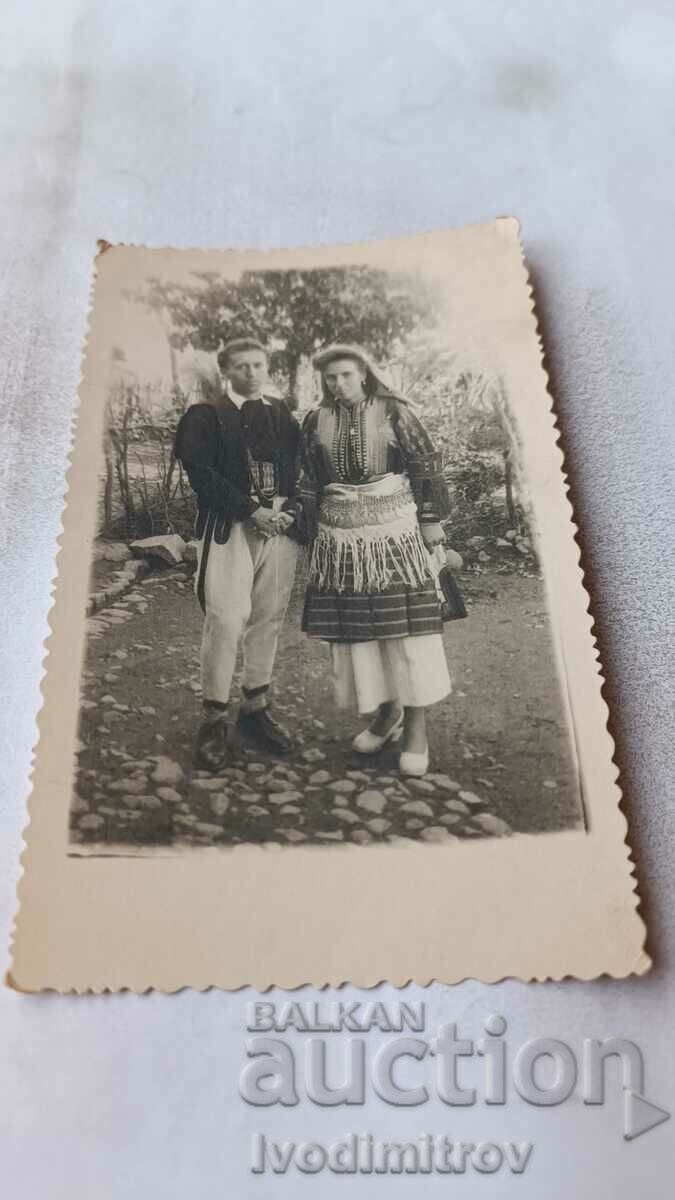 Φωτογραφία Ένας νεαρός άνδρας και μια νεαρή κοπέλα με λαϊκές φορεσιές