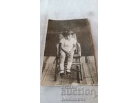 Fotografie O fetiță care stă pe un scaun de răchită