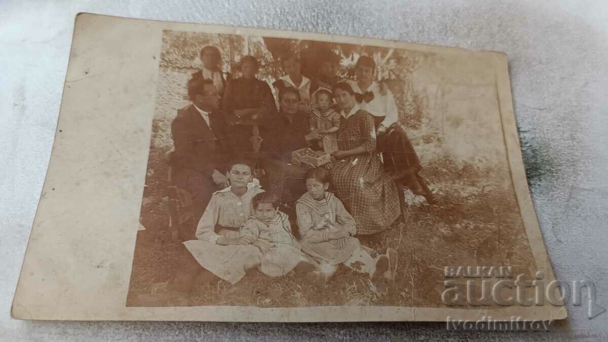Φωτογραφία Άνδρας γυναίκες και παιδιά κάτω από ένα δέντρο στην αυλή