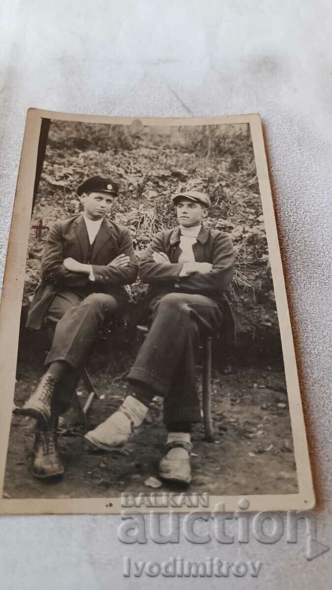 Photo Two young men sitting on a park bench