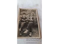 Photo Two young men sitting on a park bench