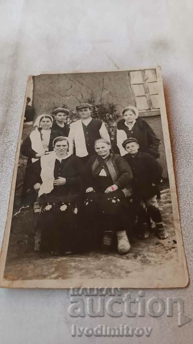 Photo Men, women and a boy in the yard of their house
