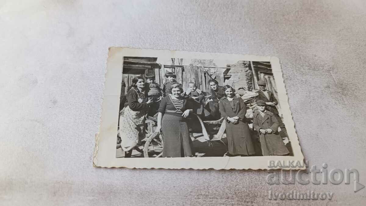 Снимка Мъже жени и деца на каруца в двора